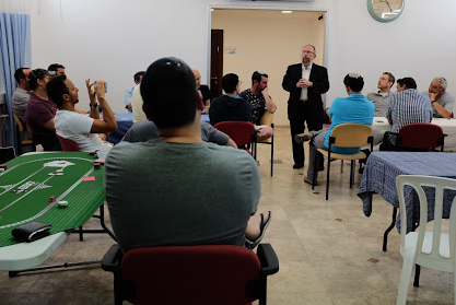 Rabbi Elimelech Goldberg speaks to the charity poker players about Kids Kicking Cancer